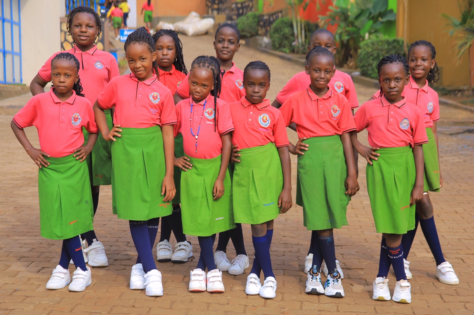 Pamville pupils wearing coral polo shirts and green sports skirts