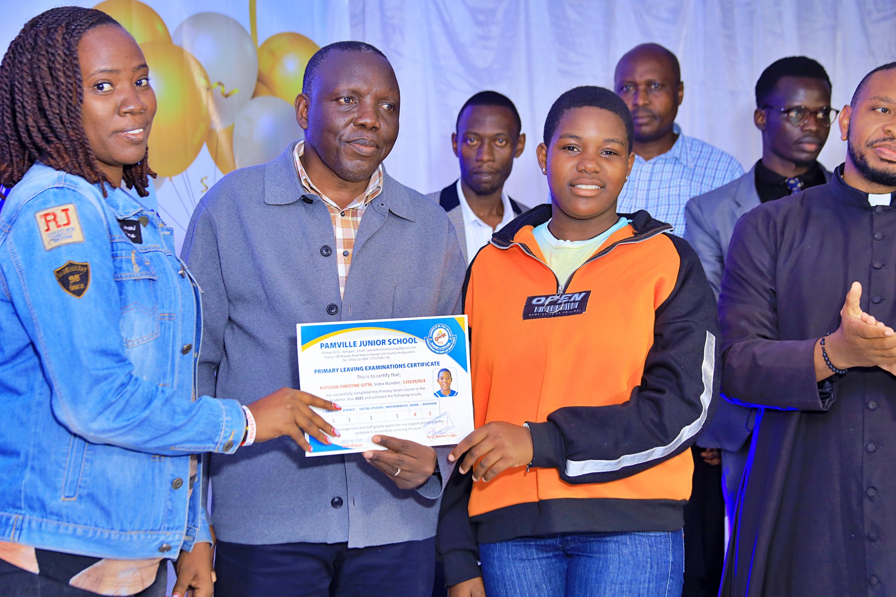 Pamville learner receiving a Primary Leaving Examinations certificate with family and school representatives